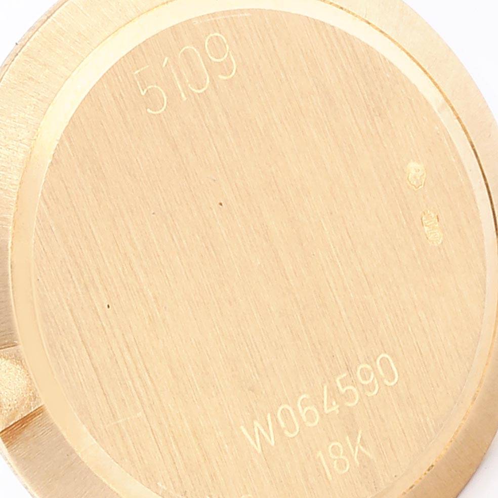 This is the back casing of a Rolex Cellini 5109 Women's Yellow Gold Champagne Dial 5109 Women's Yellow Gold Champagne Dial model watch, showcasing serial numbers and an 18K gold mark.