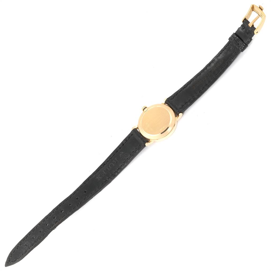 The image shows an overhead view of a Rolex Cellini 5109 Women's Yellow Gold Champagne Dial 5109 Women's Yellow Gold Champagne Dial watch, highlighting its black leather strap and gold-tone case.
