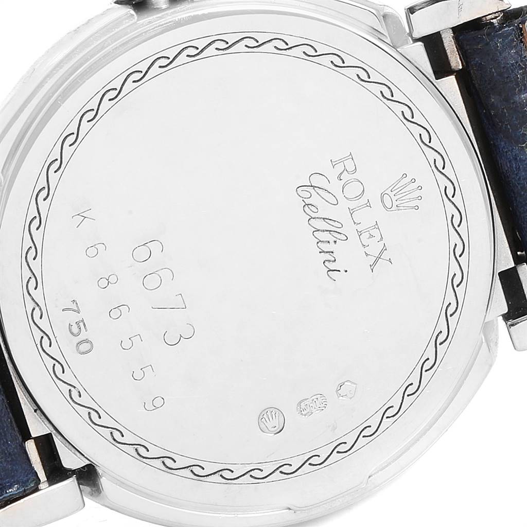 The image shows the back case of a Rolex Cellini 6673 Women
s White Gold Silver Dial 6673 Women
s White Gold Silver Dial watch, featuring engraved details and a partially visible strap.