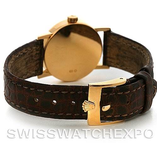 The Rolex Cellini 6110 Women's Yellow Gold Silver Dial 6110 Women's Yellow Gold Silver Dial watch is shown from the rear, displaying its brown leather strap and gold clasp with the watch crown.