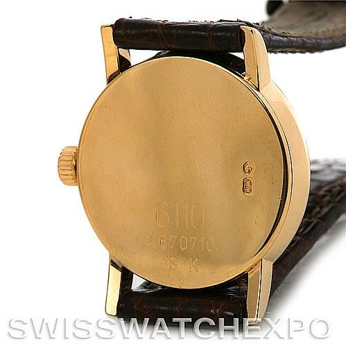 This image shows the back of a Rolex Cellini 6110 Women's Yellow Gold Silver Dial 6110 Women's Yellow Gold Silver Dial watch, featuring its case, crown, and leather strap.