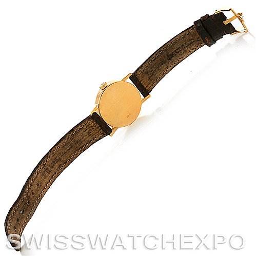 This Rolex Cellini 6110 Women's Yellow Gold Silver Dial 6110 Women's Yellow Gold Silver Dial watch is displayed from the back, showcasing its strap and golden case.