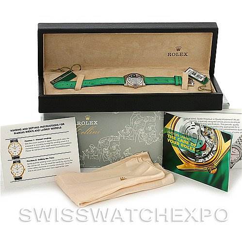 The image displays a Rolex Cellini 5310 Women's White Gold Mother of Pearl Dial 5310 Women's White Gold Mother of Pearl Dial watch with a green strap in its box, accompanied by watch manuals and a cloth.