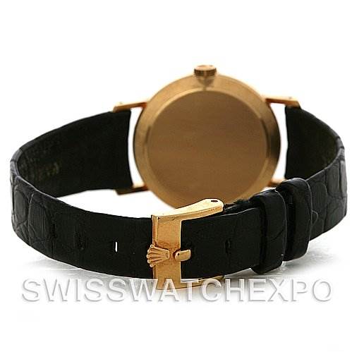 The image shows the back view of a Rolex Cellini 4109 Women
s Yellow Gold White Dial 4109 Women
s Yellow Gold White Dial watch, highlighting its black strap and gold clasp.