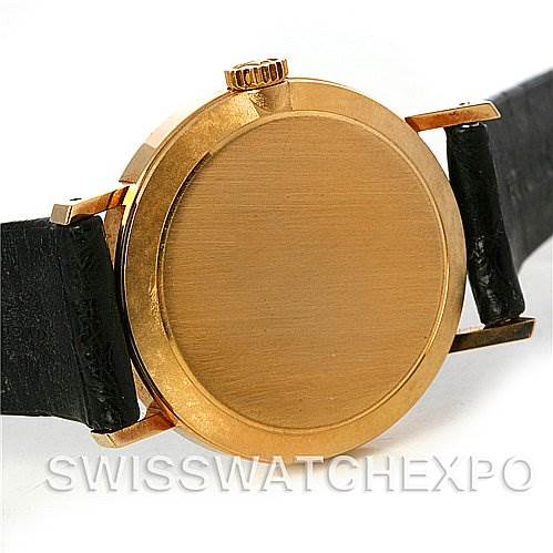 This image shows the back case and crown of a Rolex Cellini 4109 Women
s Yellow Gold White Dial 4109 Women
s Yellow Gold White Dial watch, with black leather straps partially visible.