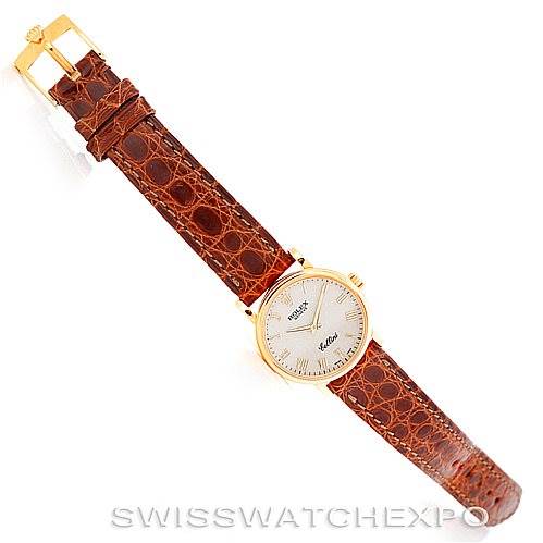 The image shows a top-down view of a Rolex Cellini 6110 Women's Yellow Gold Beige Dial 6110 Women's Yellow Gold Beige Dial watch with a brown leather strap and a gold bezel.