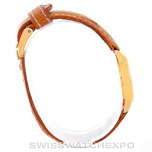 This image shows a side view of a Rolex Cellini 6110 Women's Yellow Gold Silver Dial 6110 Women's Yellow Gold Silver Dial watch, highlighting its brown leather strap and gold case.