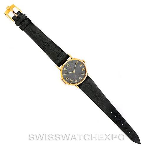 The Rolex Cellini 4306 Women's Yellow Gold Grey Dial 4306 Women's Yellow Gold Grey Dial model watch is shown from a top-down angle, displaying its full length, black leather strap, and gold case.