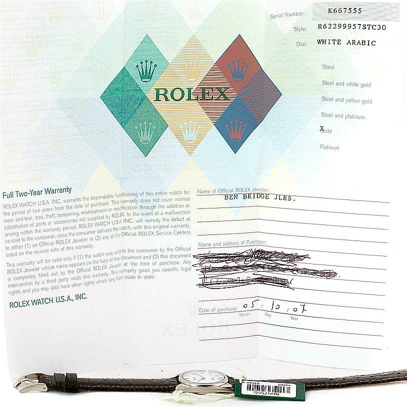The image shows a Rolex Cellini 6229 Women's White Gold White Dial 6229 Women's White Gold White Dial watch lying horizontally with its warranty card, displaying details and dealer information.