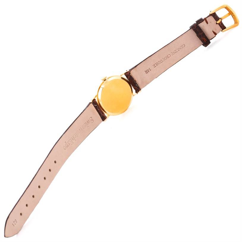 The image shows the rear view of a Rolex Cellini 3810 Women's Yellow Gold Champagne Dial 3810 Women's Yellow Gold Champagne Dial watch, highlighting the gold case and leather strap with a clasp.