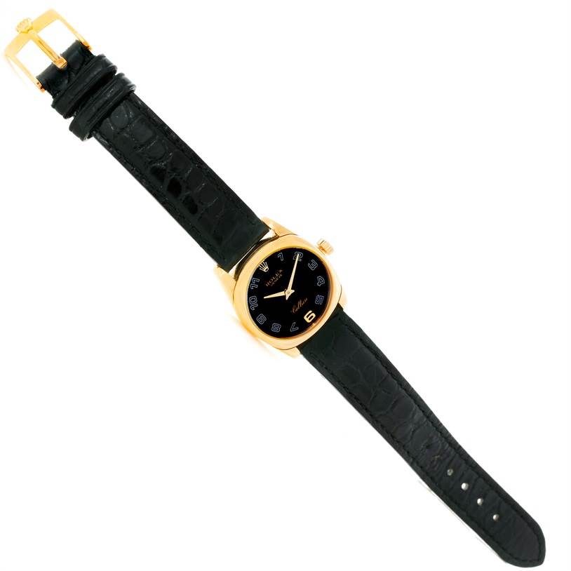 The Rolex Cellini 6229 Women's Yellow Gold Black Dial 6229 Women's Yellow Gold Black Dial model watch is shown from an overhead angle, displaying the entire face, case, and leather strap.