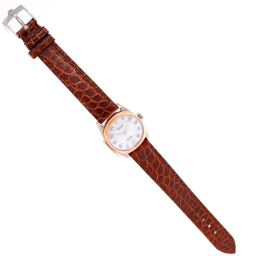 The image shows a top-down view of a Rolex Cellini 6229 Women's White Gold White Dial 6229 Women's White Gold White Dial watch with a brown leather strap and a silver and gold case.