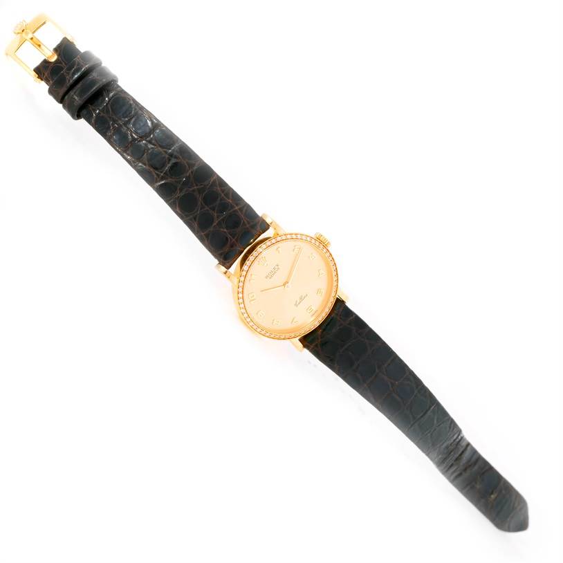 The image shows a Rolex Cellini 5113 Women's Yellow Gold Champagne Dial 5113 Women's Yellow Gold Champagne Dial watch from a top-down angle, displaying the dial, case, and leather strap.