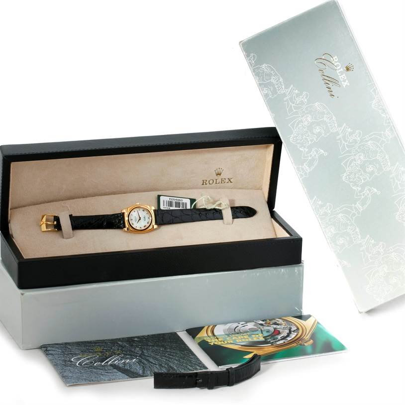 The image shows a Rolex Cellini 5310 Women's Yellow Gold Mother of Pearl Dial 5310 Women's Yellow Gold Mother of Pearl Dial watch from a top angle in its box, alongside its outer box, manuals, and an extra strap.