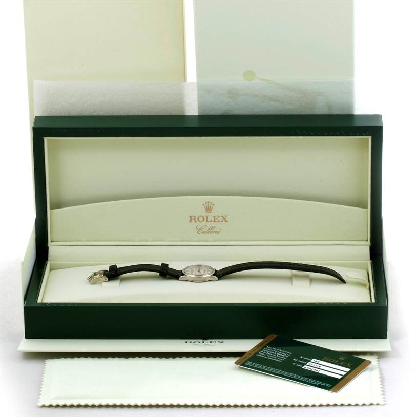 The image shows a Rolex Cellini 6111 Women's White Gold Silver Dial 6111 Women's White Gold Silver Dial watch in its open green and white box, accompanied by a card and cleaning cloth.