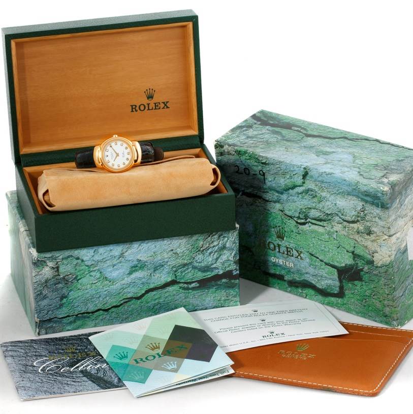 The image shows a Rolex Cellini 6621 Women's Yellow Gold White Dial 6621 Women's Yellow Gold White Dial watch at a front angle inside its box, accompanied by manuals and warranty card.