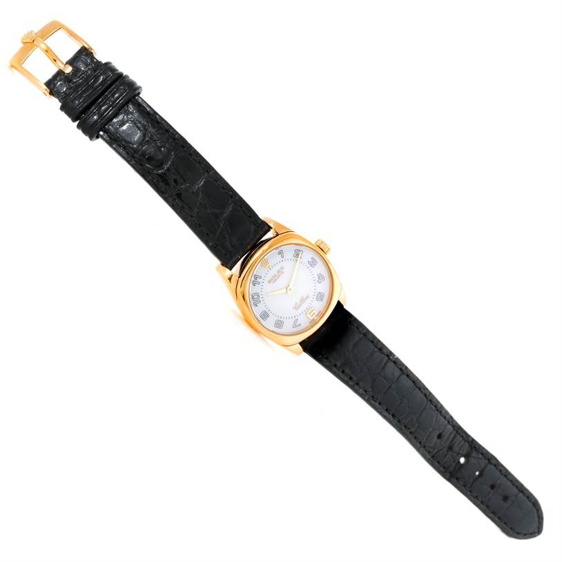 The Rolex Cellini 6229 Women's Yellow Gold White Dial 6229 Women's Yellow Gold White Dial watch is shown from a top-down angle, displaying the entire watch including the face, case, and black strap.