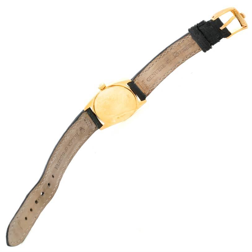 The image shows the back view of a Rolex Cellini 6229 Women's Yellow Gold White Dial 6229 Women's Yellow Gold White Dial watch, highlighting its case, crown, and leather strap with a gold buckle.