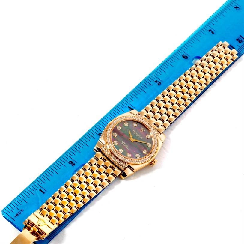 The Rolex Cellini 6321 Women's Yellow Gold Mother of Pearl Dial 6321 Women's Yellow Gold Mother of Pearl Dial watch is shown from a top-down angle alongside a blue ruler.