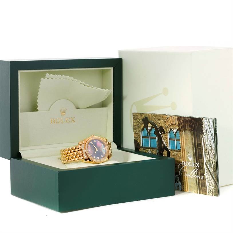 The Rolex Cellini 6321 Women's Yellow Gold Mother of Pearl Dial 6321 Women's Yellow Gold Mother of Pearl Dial watch is presented at an angle inside an open box, accompanied by a cleaning cloth and a booklet.