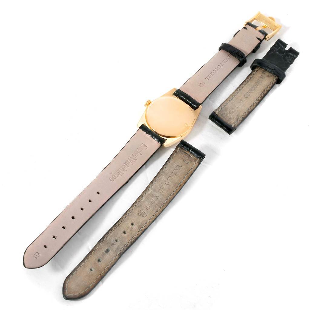 This image shows the back of a Rolex Cellini 6229 Women's Yellow Gold Black Dial 6229 Women's Yellow Gold Black Dial watch and its detached leather straps.