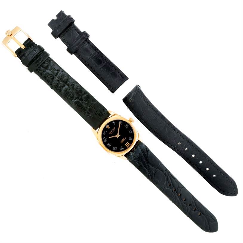 The image shows a Rolex Cellini 6229 Women's Yellow Gold Black Dial 6229 Women's Yellow Gold Black Dial watch and three black leather straps, viewed from a top-down angle.
