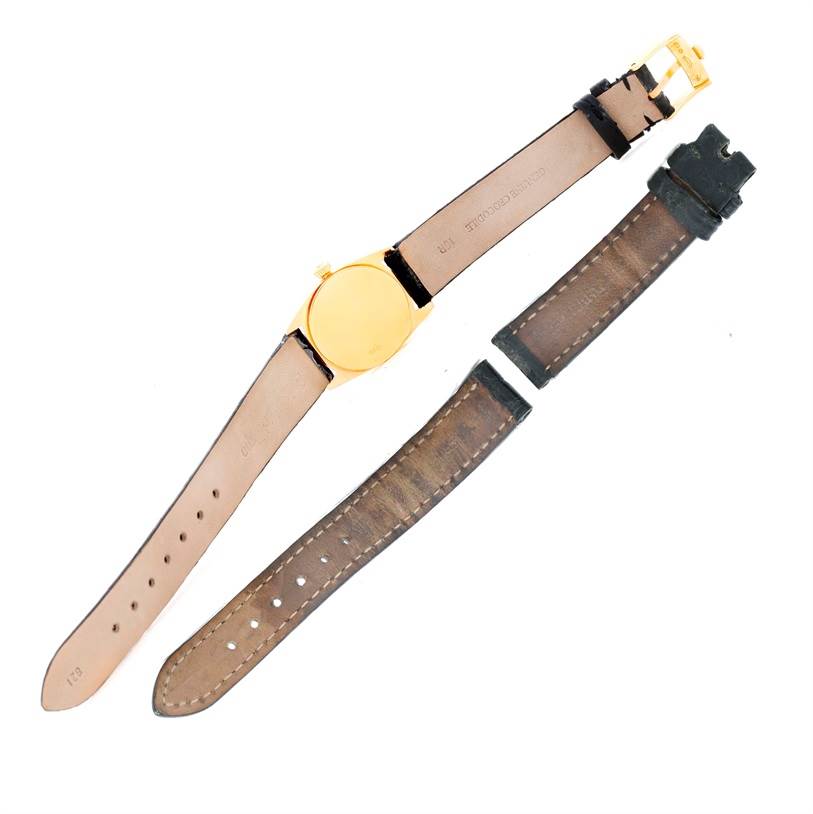 The image shows the back side of a Rolex Cellini 6229 Women's Yellow Gold Black Dial 6229 Women's Yellow Gold Black Dial watch and replacement straps laid flat.