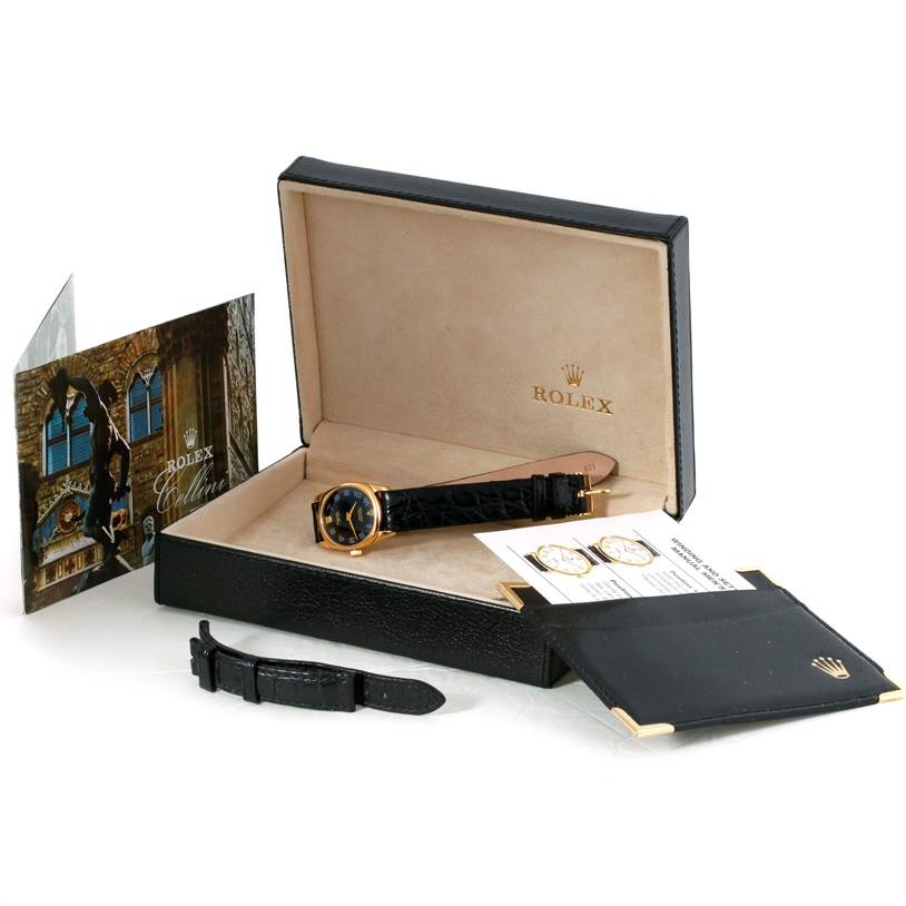 The image shows the Rolex Cellini 6229 Women's Yellow Gold Black Dial 6229 Women's Yellow Gold Black Dial watch in its open box with documentation, additional strap, and accessories.