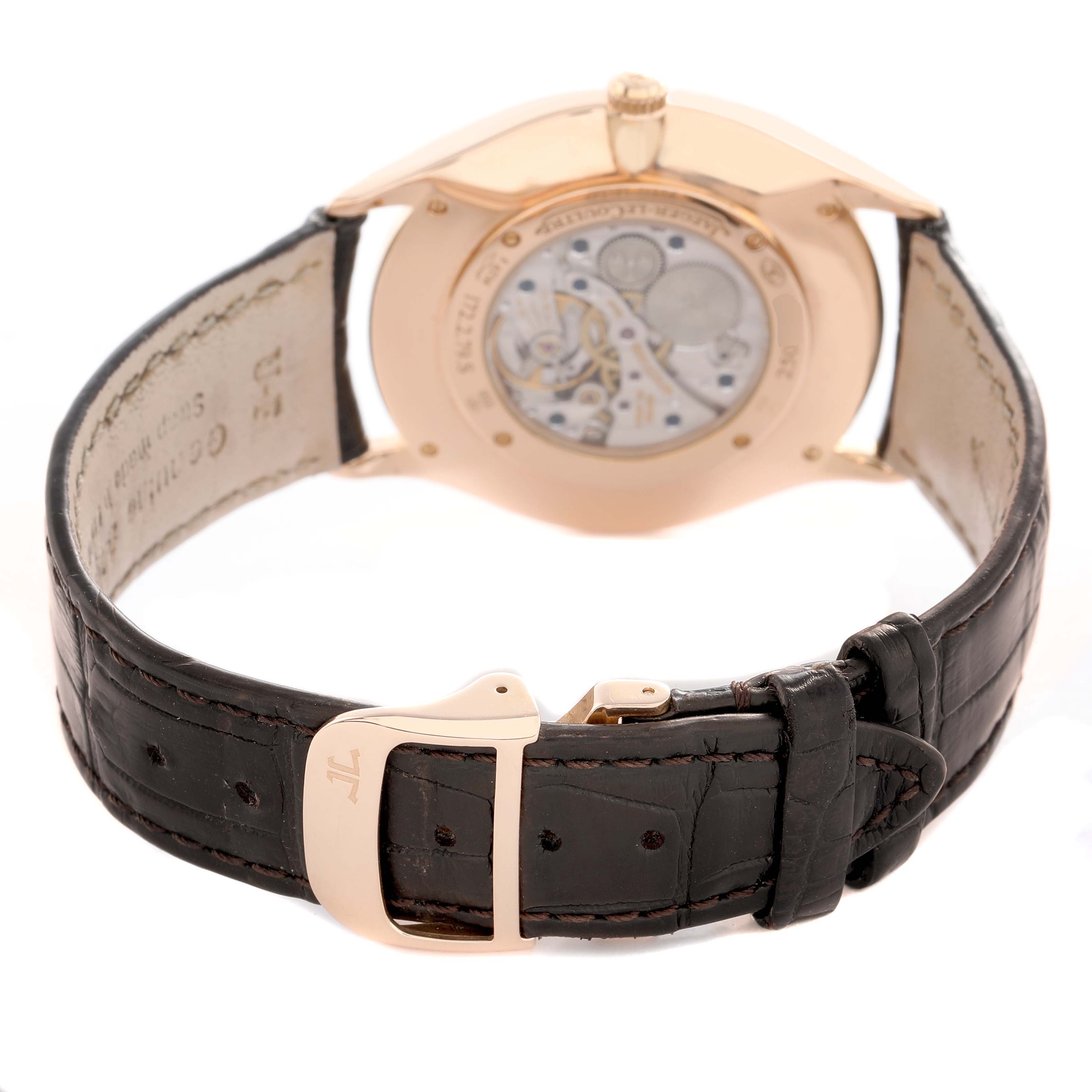 The Jaeger-LeCoultre Master watch is shown from the rear angle, highlighting the open case back and brown leather strap.