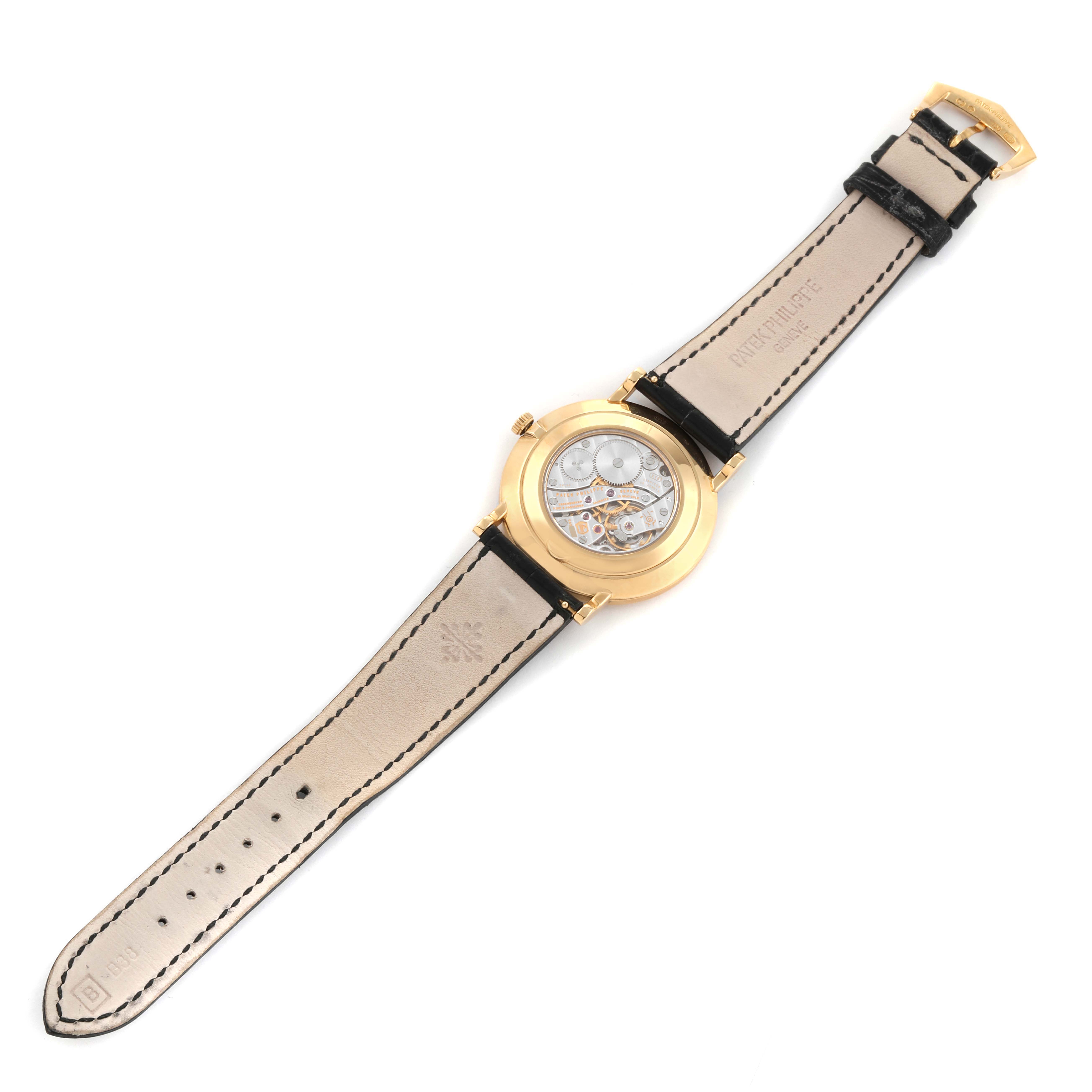 The image shows the back view of the Patek Philippe Calatrava 5119J Men
s Yellow Gold White Dial 5119J Men
s Yellow Gold White Dial watch, displaying its leather strap and inner mechanism.
