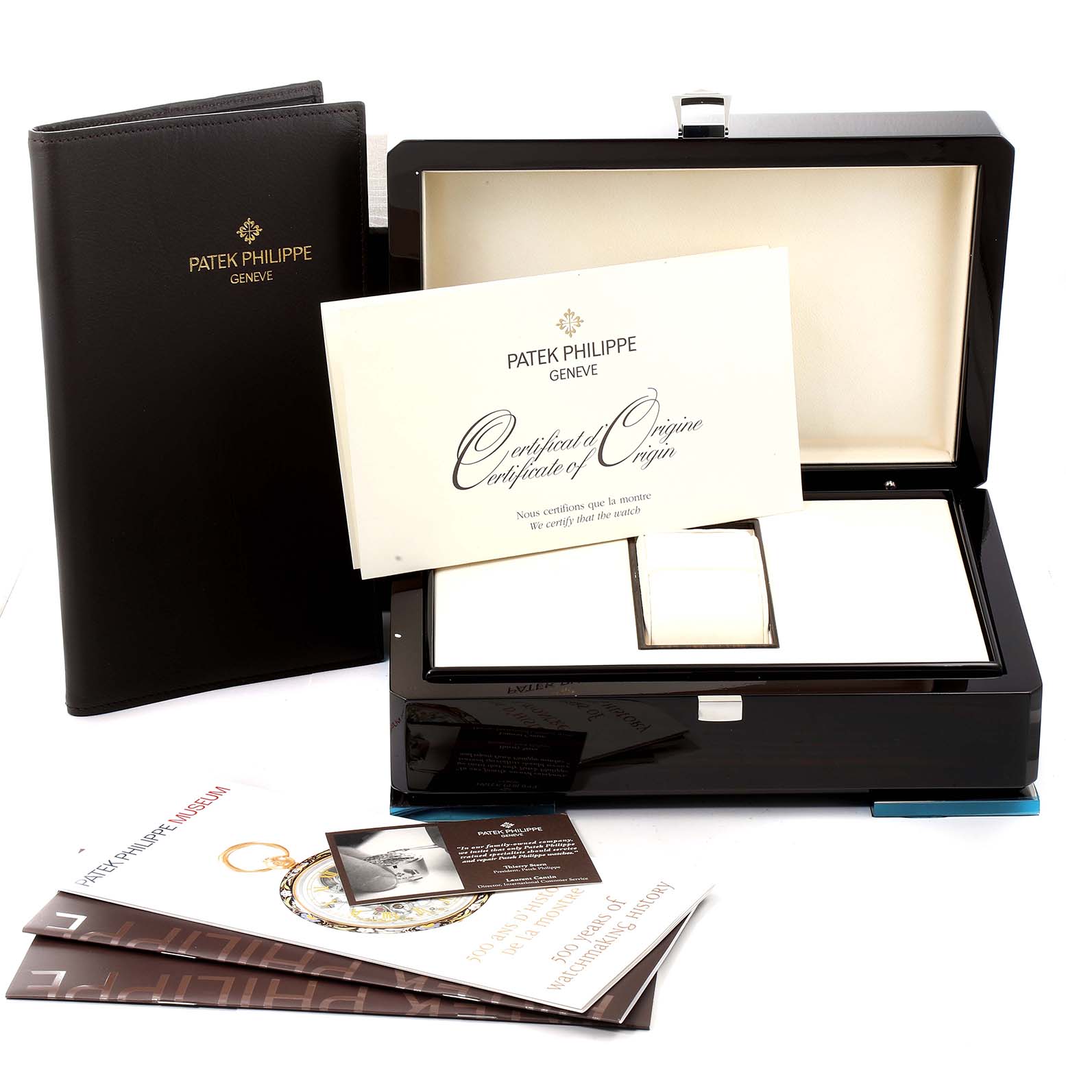 The image shows the box, certificate, and accessories of a Patek Philippe Twenty-4 4910/10A-010 Women's Stainless Steel Silver Dial 4910/10A-010 Women's Stainless Steel Silver Dial model watch from an angled view.