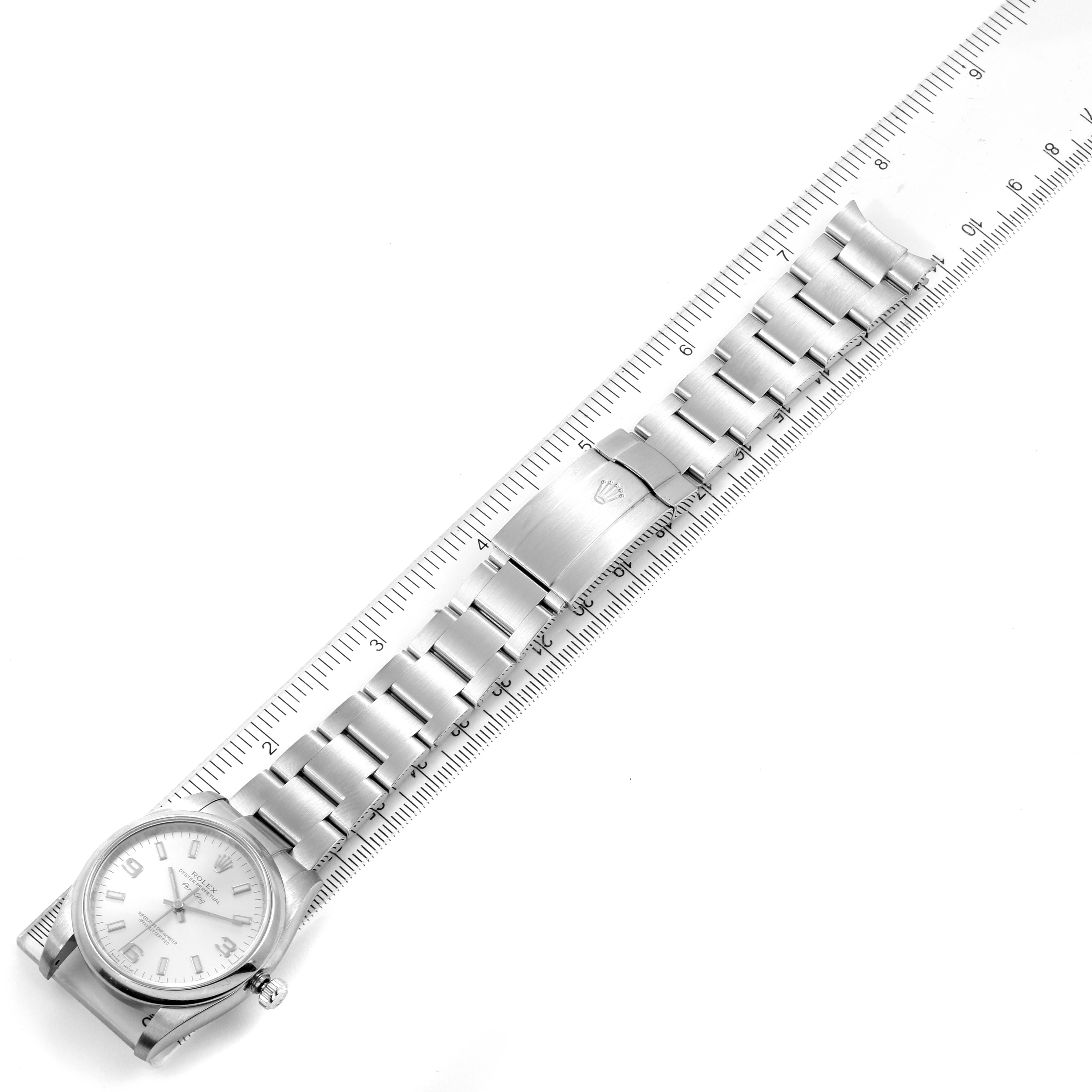 This image shows the Rolex Air-King 114200 Men's Stainless Steel Silver Dial 114200 Men's Stainless Steel Silver Dial watch laid flat with its stainless steel bracelet measured against a ruler.