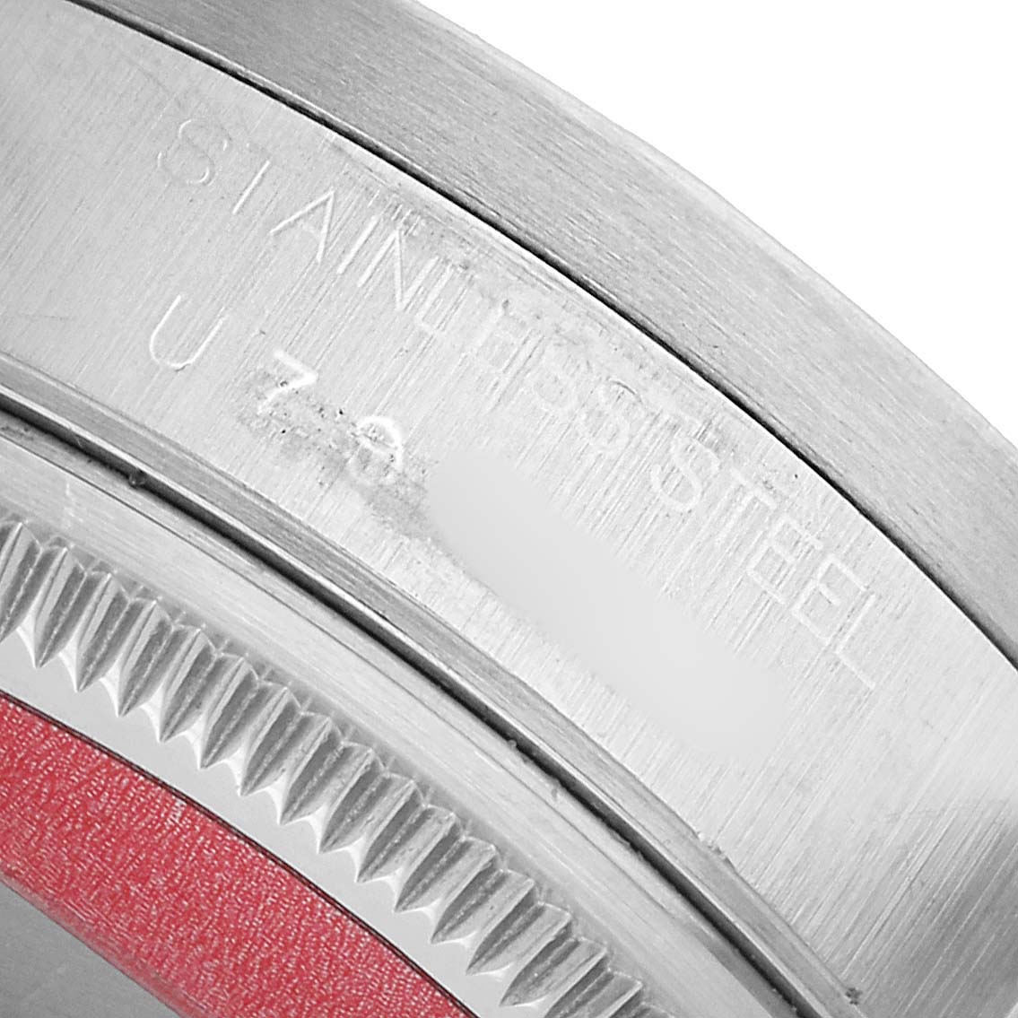 The image shows a close-up of the bezel edge and part of the case back for the Rolex Date 15210 Men's Stainless Steel Black Dial watch, emphasizing the stainless steel material.