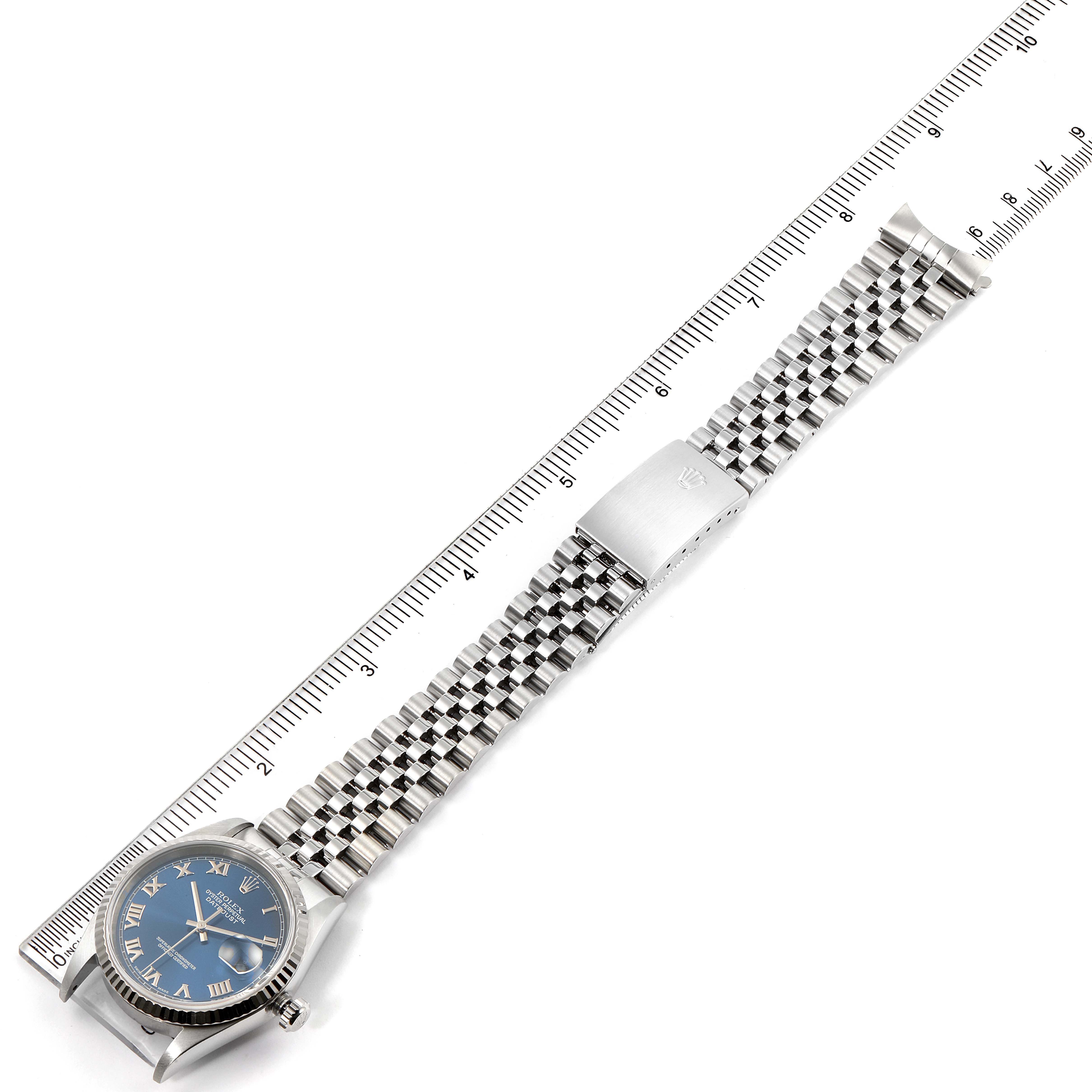 This image shows a Rolex Datejust 16234 Men's Stainless Steel Blue Dial 16234 Men's Stainless Steel Blue Dial watch laid flat, displaying the face, case, and full metal bracelet with a clasp next to a ruler.