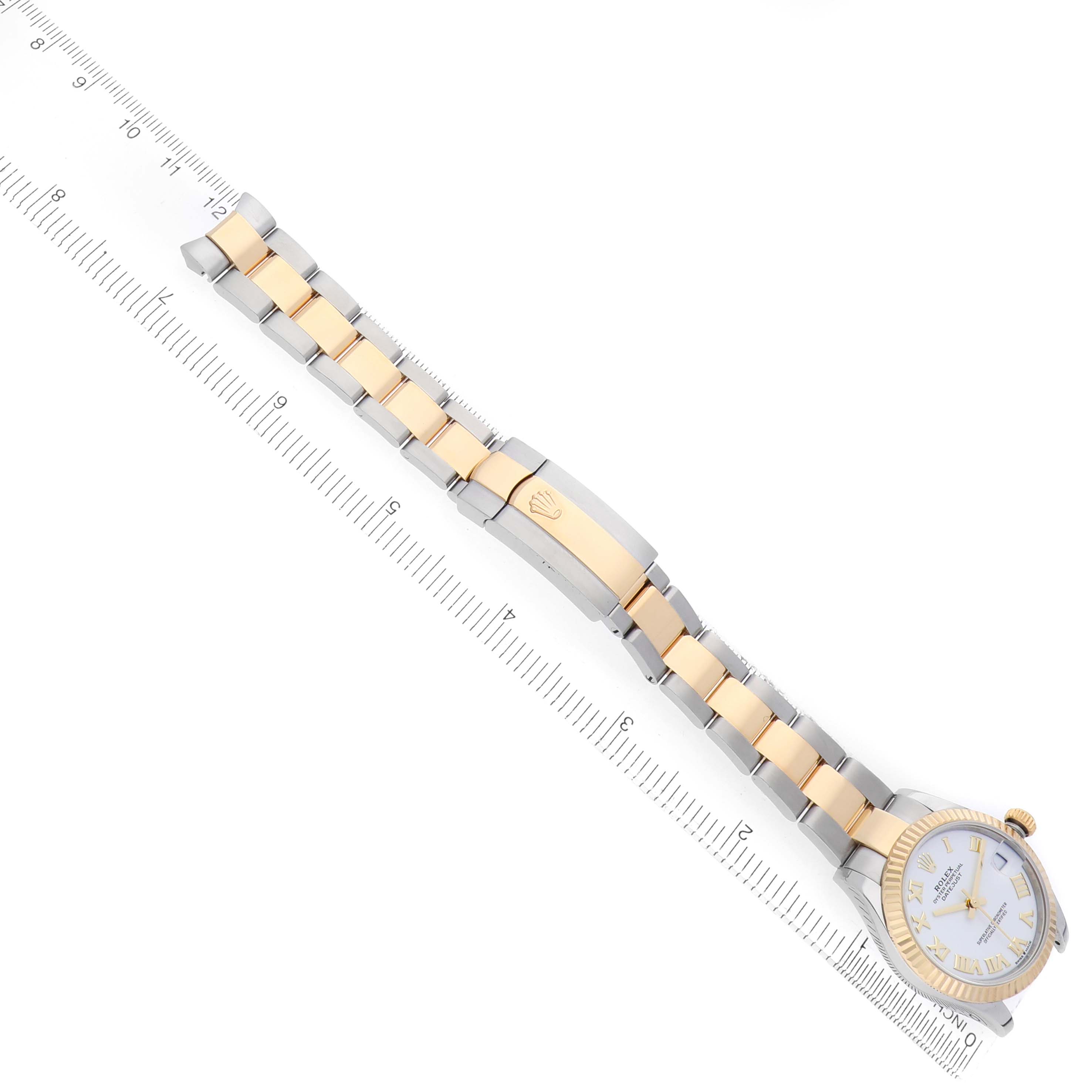 The image shows a Rolex Mid-Size 278273 Women's Steel and Gold (two tone) White Dial watch from a top-down angle, displaying the band, clasp, and face next to a ruler.