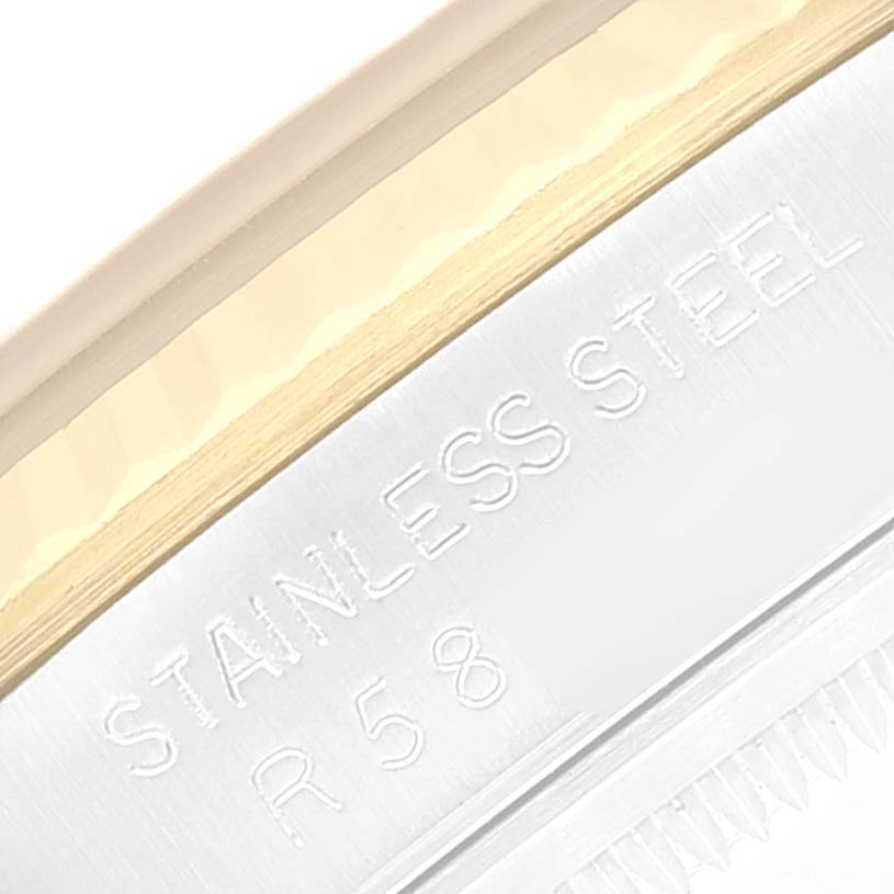 This close-up of the Rolex Datejust 16233 Men's Steel and Gold (two tone) Champagne Dial 16233 Men's Steel and Gold (two tone) Champagne Dial model shows part of the case with "STAINLESS STEEL" and some reference numbers engraved.