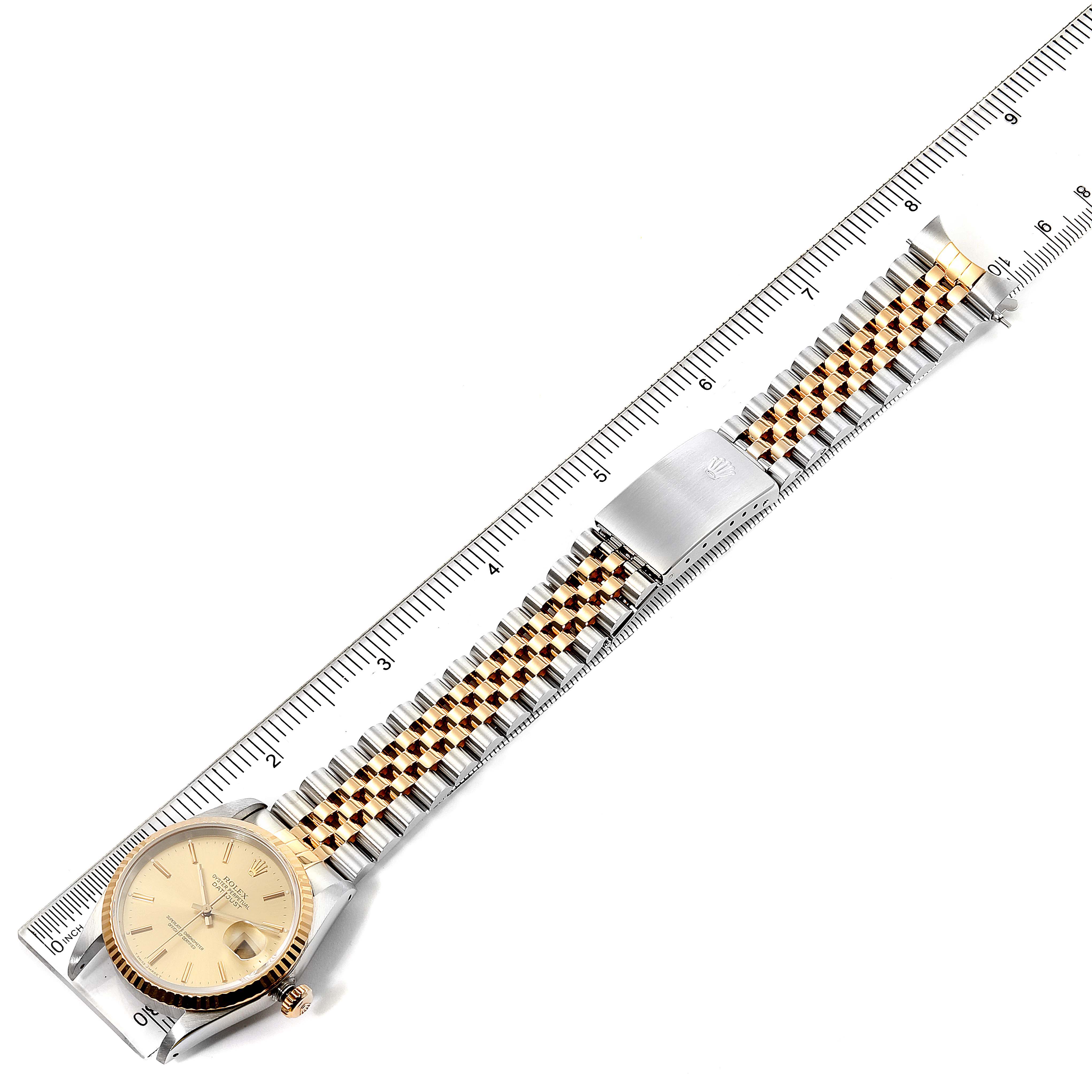 The image shows a Rolex Datejust 16233 Men's Steel and Gold (two tone) Champagne Dial 16233 Men's Steel and Gold (two tone) Champagne Dial watch laid flat next to a ruler, displaying the face, bezel, bracelet, and clasp.