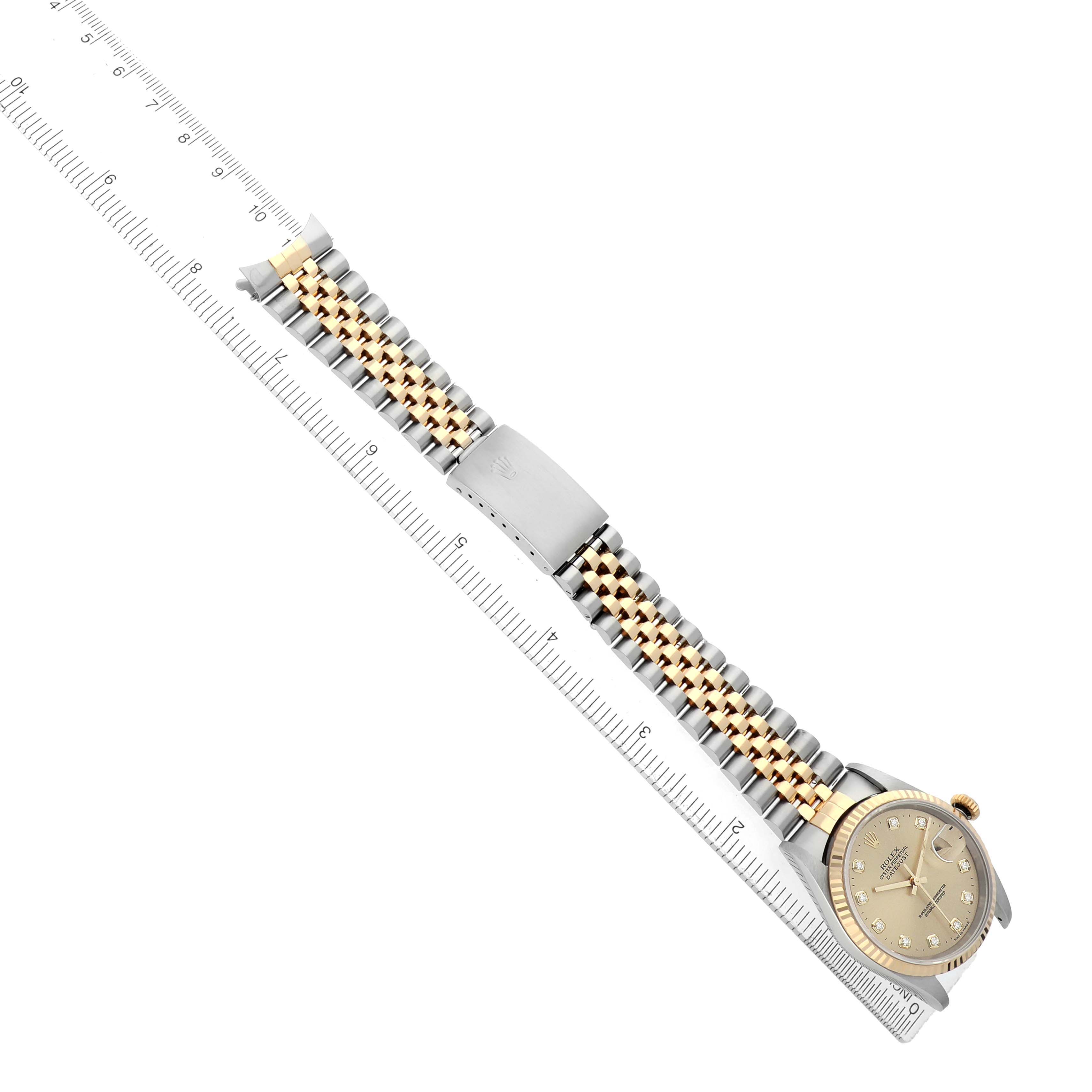 The Rolex Datejust 16233 Men's Steel and Gold (two tone) Champagne Dial watch is shown from a top angle, featuring its bracelet, clasp, and face along a ruler for scale.