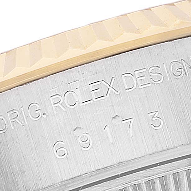 This image shows a close-up of the Rolex Datejust 69173 Women's Steel and Gold (two tone) White Dial 69173 Women's Steel and Gold (two tone) White Dial model's bezel and engraved casing.