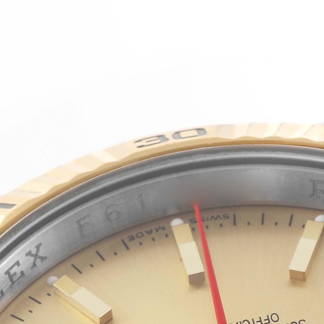 The image shows a close-up of the bezel, dial, and markers of a Rolex Turn-o-Graph 116263 Men's Steel and Gold (two tone) Champagne Dial watch, emphasizing the gold-tone elements and red hand.