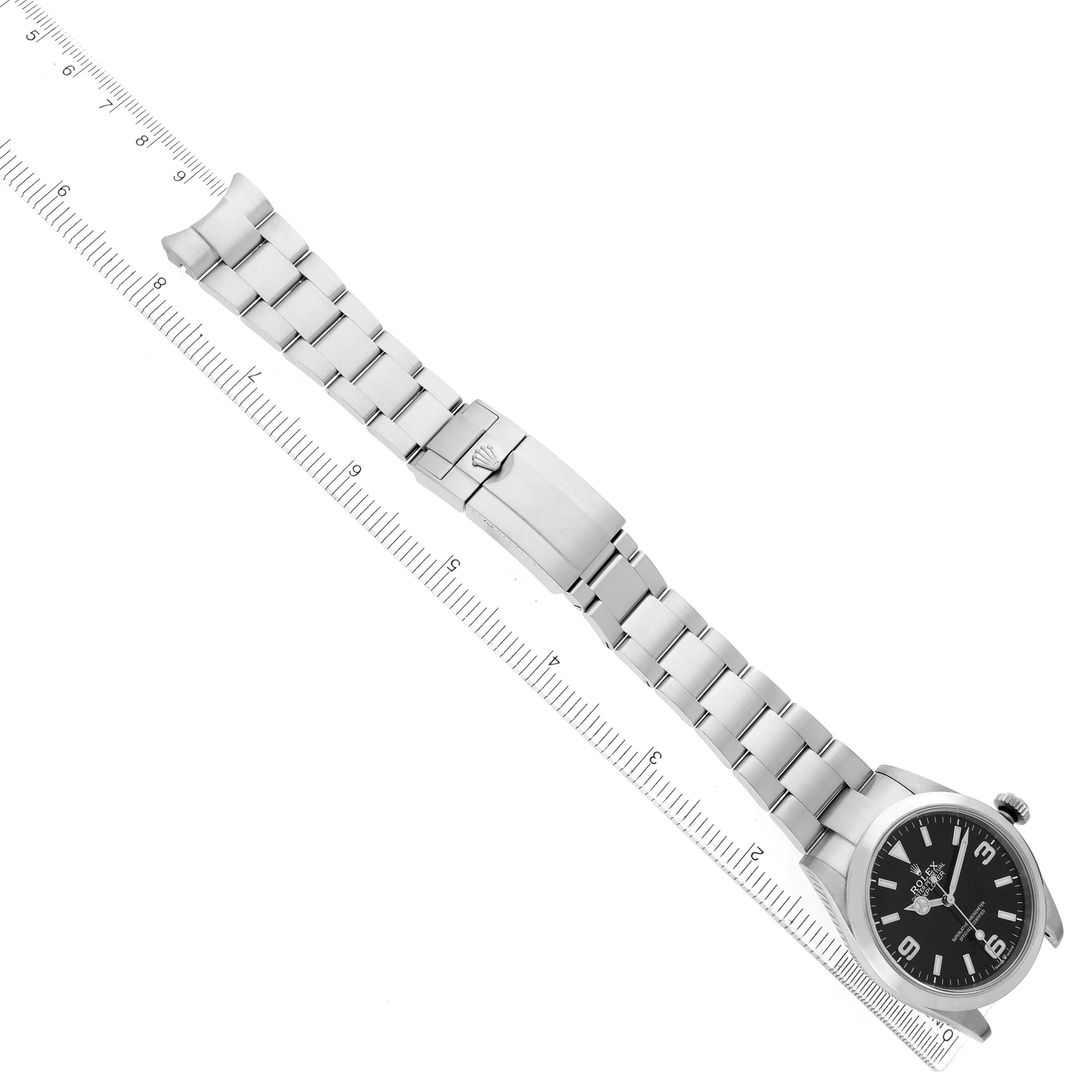 The Rolex Explorer 224270 Men's Stainless Steel Black Dial watch is shown laid flat with the face, bracelet, and clasp visible alongside a ruler for scale.