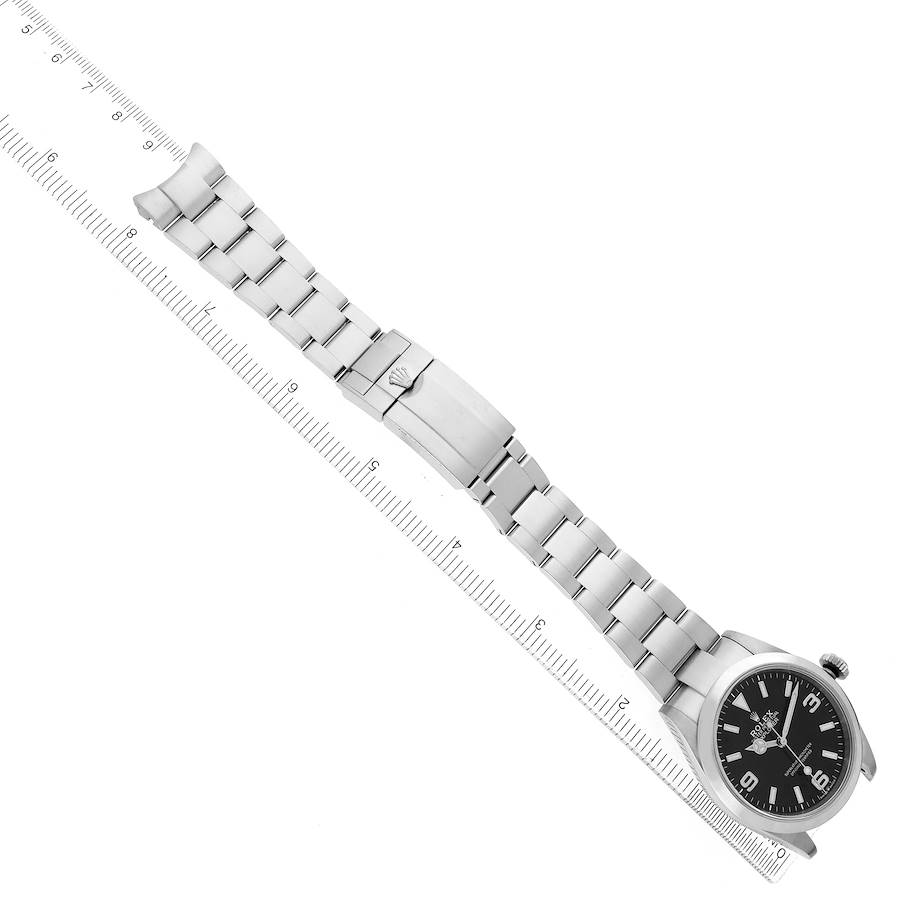 The Rolex Explorer 224270 Men's Stainless Steel Black Dial watch is shown laid flat with the face, bracelet, and clasp visible alongside a ruler for scale.