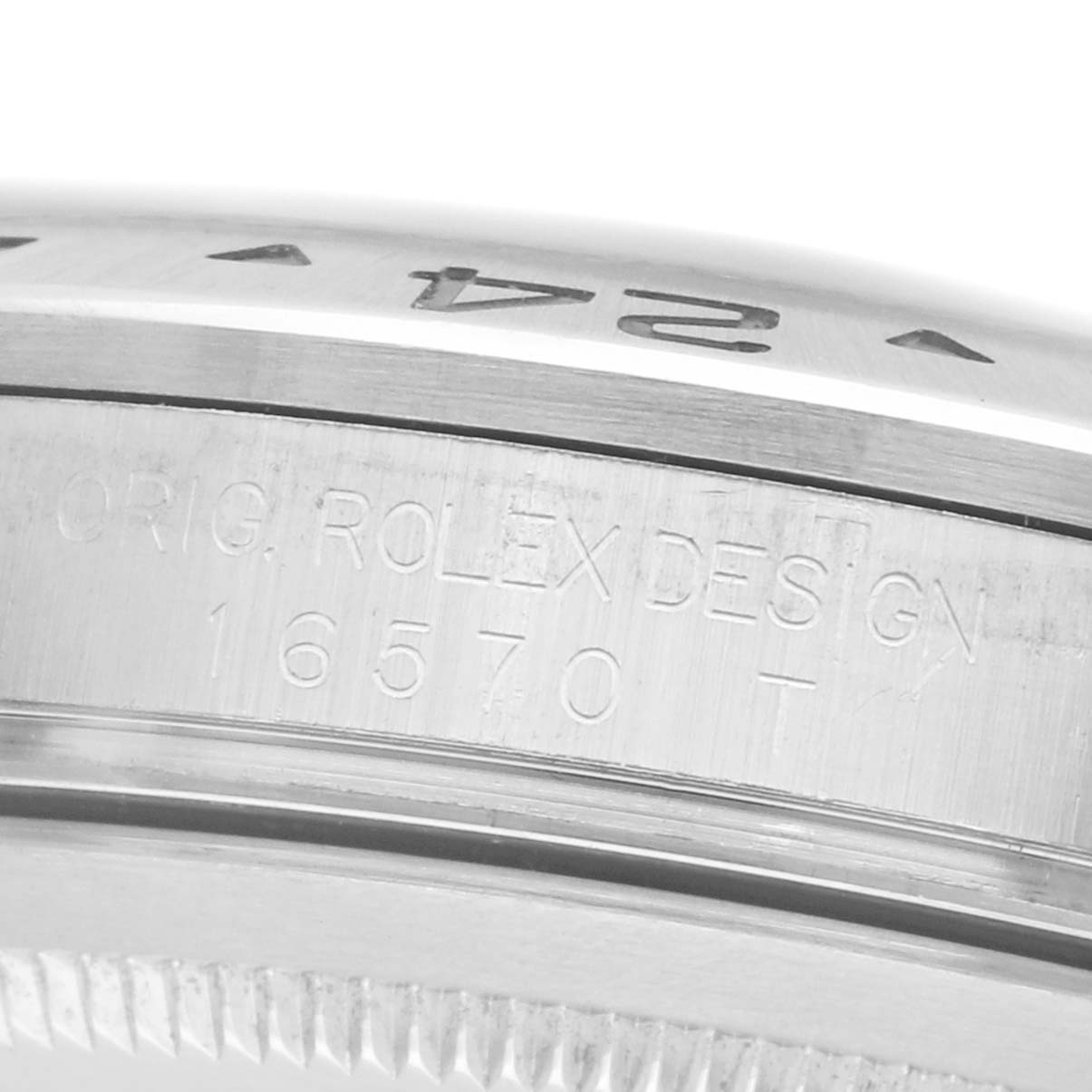 The image shows a close-up of a Rolex Explorer 16570 Men's Stainless Steel White Dial model's engraved watch bezel with the design and model numbers visible.