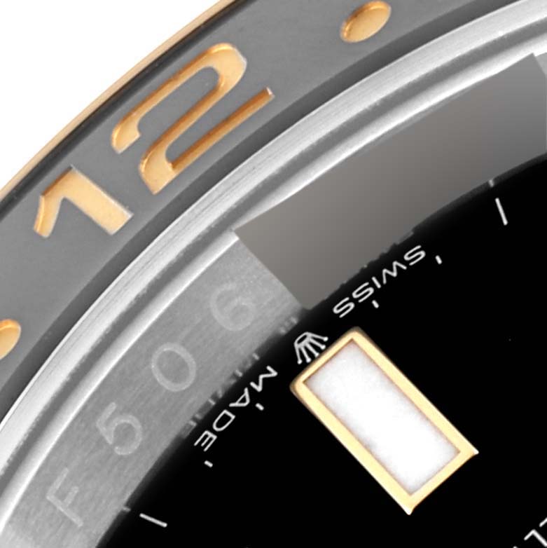 This close-up image of a Rolex GMT-Master 126713 Men's Steel and Gold (two tone) Black Dial 126713 Men's Steel and Gold (two tone) Black Dial watch highlights the bezel, dial, and 'Swiss Made' text under the 12 o'clock marker.