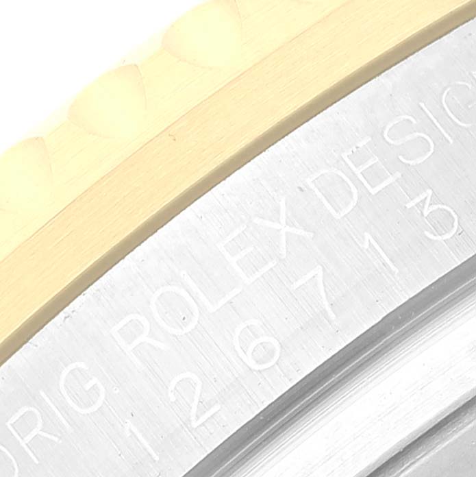 The image shows a close-up of the engraved text and partial bezel on a Rolex GMT-Master 126713 Men's Steel and Gold (two tone) Black Dial 126713 Men's Steel and Gold (two tone) Black Dial watch.