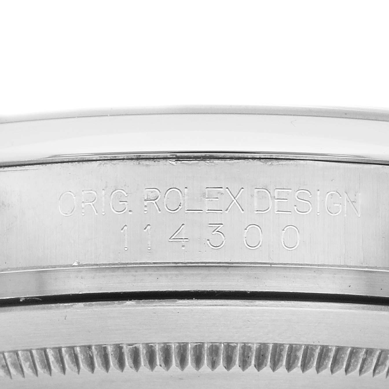 The image shows a side view of the Rolex Oyster Perpetual 114300 Men's Stainless Steel Blue Dial model, focusing on the engraved case with model number 114300.