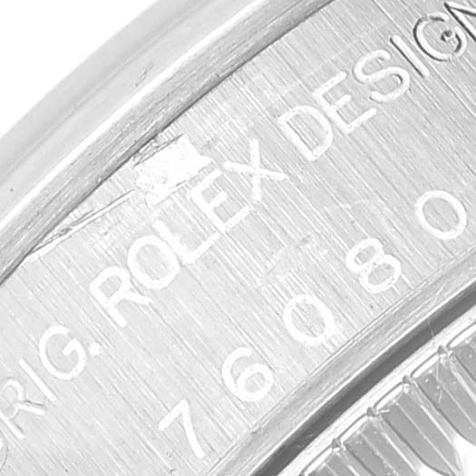 This close-up image shows the engraved markings on the case back edge of a Rolex Oyster Perpetual 76080 Women's Stainless Steel Silver Dial 76080 Women's Stainless Steel Silver Dial watch.
