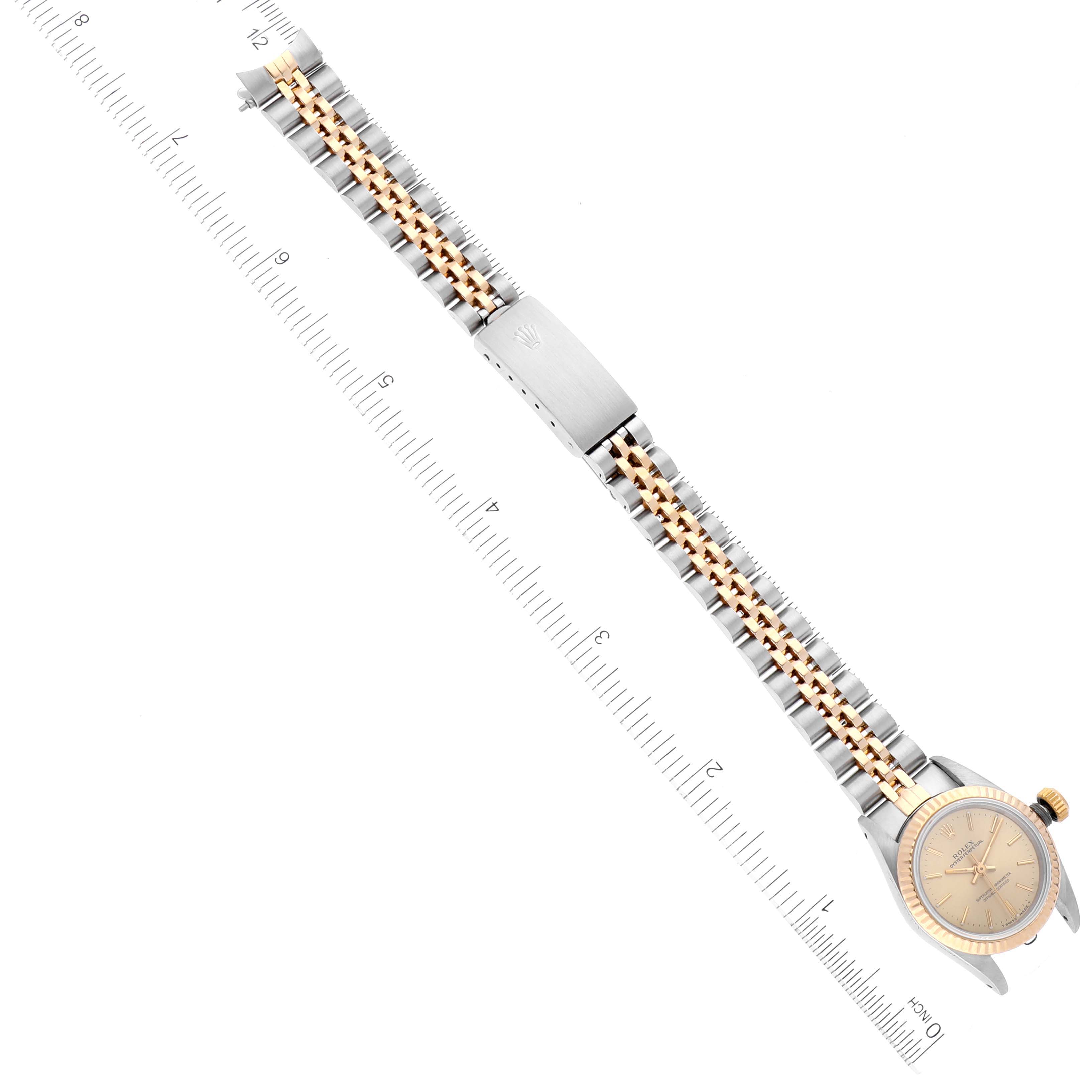 This image shows a top-down view of a Rolex Oyster Perpetual 67193 Women's Steel and Gold (two tone) Champagne Dial 67193 Women's Steel and Gold (two tone) Champagne Dial watch, highlighting its bracelet and clasp.