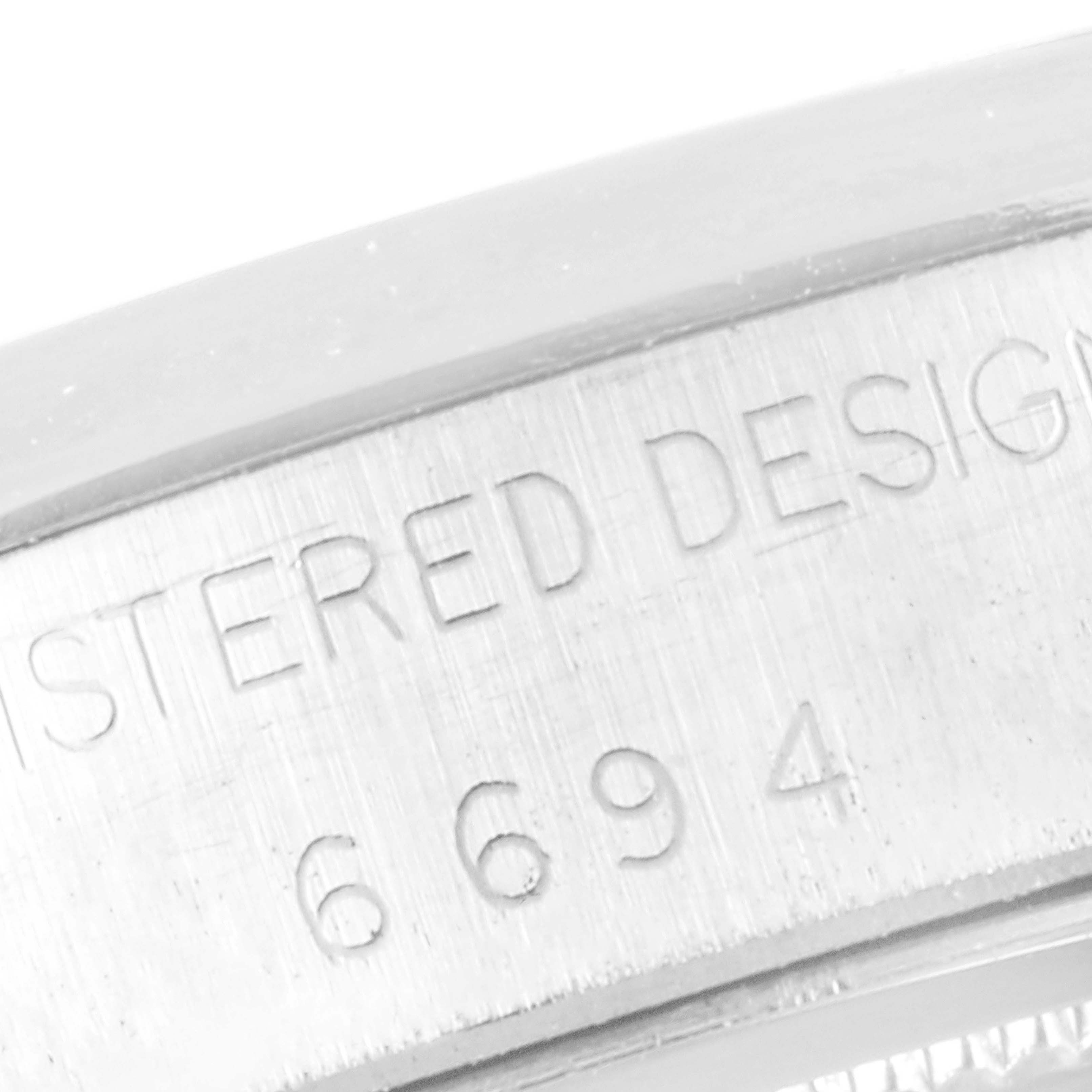 This close-up image displays the engraved edge of a Rolex Vintage Collection 6694 Men's Stainless Steel Silver Dial 6694 Men's Stainless Steel Silver Dial watch case, emphasizing the "REGISTERED DESIGN" and model number "6694."
