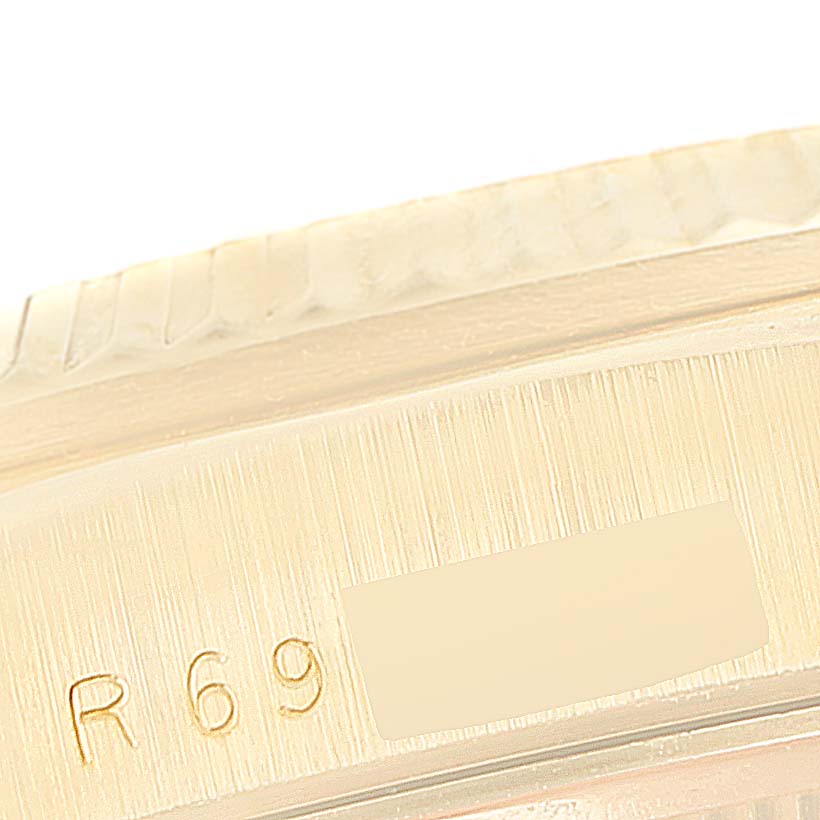 This is a close-up shot of the engraved case side of a Rolex President 18238 Men
s Yellow Gold Champagne Dial 18238 Men
s Yellow Gold Champagne Dial watch, showing part of the serial number.